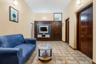 a living room with a blue couch and a table at Treebo Dunag in Coimbatore