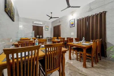 a dining room with wooden tables and chairs at Treebo Dunag in Coimbatore