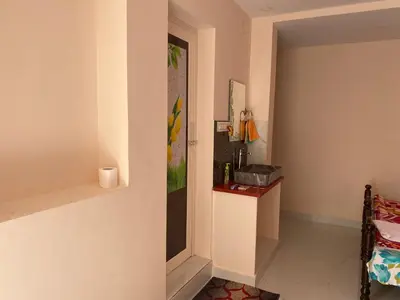 a room with a hallway with a door and a table at Abhi home stay in Mysore