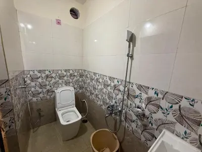 a bathroom with a toilet and a sink at green mountain homestay in Ooty