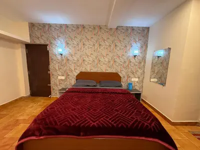 a bedroom with a bed with a red comforter at green mountain homestay in Ooty