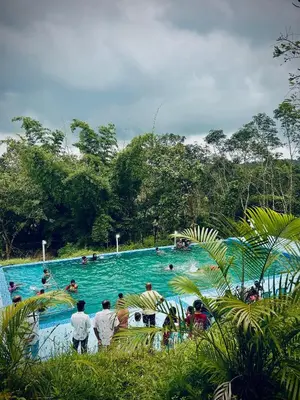 a group of people in a swimming pool at Misty Night Wayanad Pool Resort in Wayanad
