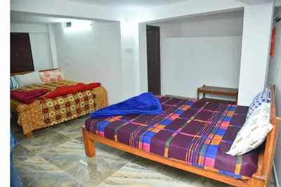a bedroom with a bed and a couch at Murugan Homestays in Vālpārai