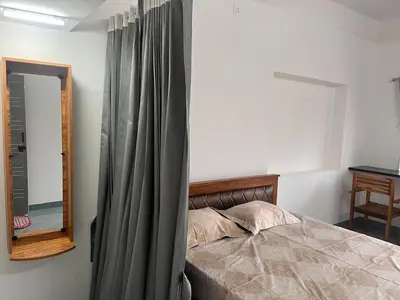 a bedroom with a bed with a curtain and a mirror at The coconest Kinathukadavu, Coimbatore in Kinattukkadavu