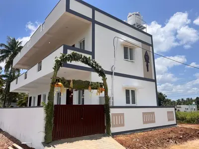 a white house with a red gate and an arch at The coconest Kinathukadavu, Coimbatore in Kinattukkadavu
