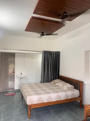 a bedroom with a bed and a ceiling at The coconest Kinathukadavu, Coimbatore in Kinattukkadavu