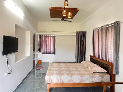 a bedroom with a bed and a flat screen tv at The coconest Kinathukadavu, Coimbatore in Kinattukkadavu