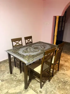 a dining room table with four chairs and a table and chairs at The Green residence in Mysore
