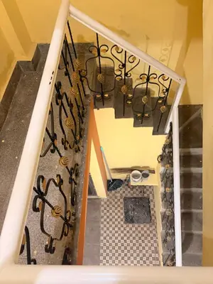 an overhead view of a staircase with iron railing at The Green residence in Mysore