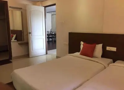a bedroom with a bed with a red pillow on it at Mysore Central 3bhk serviced apartment in Mysore