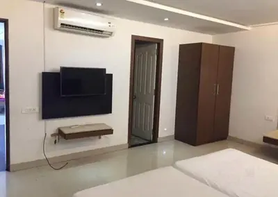 a living room with a flat screen tv on a wall at Mysore Central 3bhk serviced apartment in Mysore