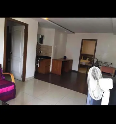 a living room with a couch and a fan at Mysore Central 3bhk serviced apartment in Mysore