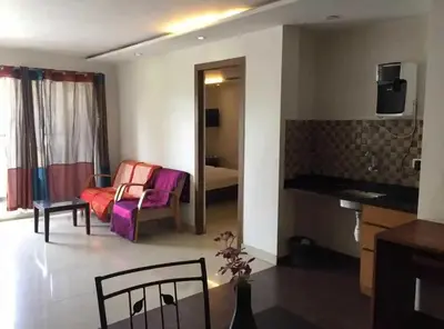 a living room with a couch and a chair at Mysore Central 3bhk serviced apartment in Mysore