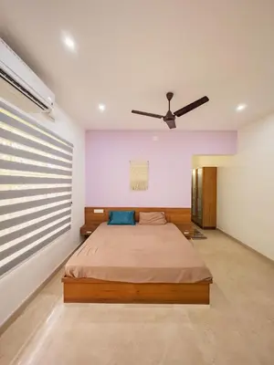 a bedroom with a bed and a ceiling fan at Akshaya Homestay in Trichūr