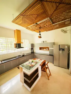 a kitchen with a table and a refrigerator at Akshaya Homestay in Trichūr