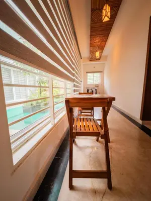 a table with a bench in front of a window at Akshaya Homestay in Trichūr