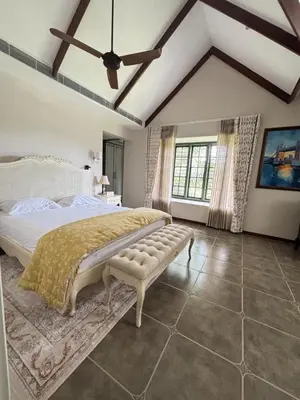 a bedroom with a large bed and a ceiling at Hanberry Luxury Cottage in Kalpetta
