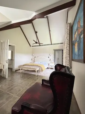 a bedroom with a bed and a couch in a room at Hanberry Luxury Cottage in Kalpetta