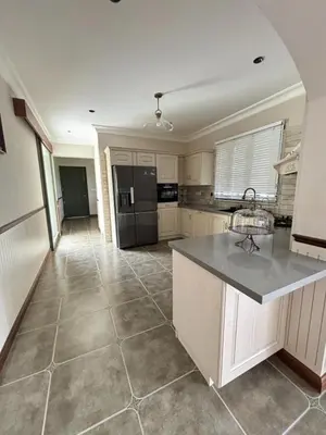 a large kitchen with a counter top and appliances at Hanberry Luxury Cottage in Kalpetta