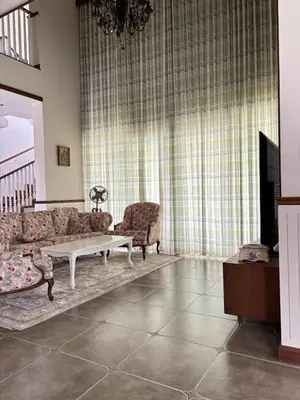 a living room with a couch and a coffee table at Hanberry Luxury Cottage in Kalpetta