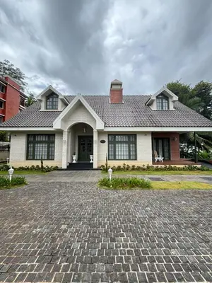 a house with a brick driveway in front of it at Hanberry Luxury Cottage in Kalpetta