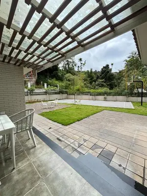 a patio with a wooden pergola with a table and bench at Hanberry Luxury Cottage in Kalpetta