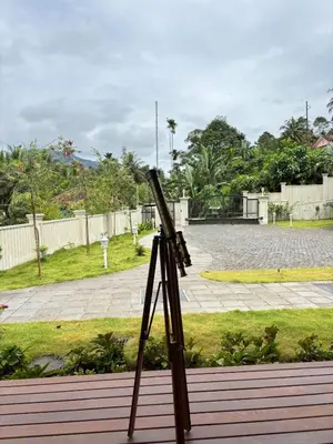 a camera on a tripod in a garden at Hanberry Luxury Cottage in Kalpetta