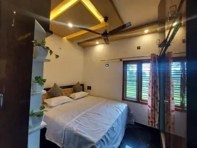 a bedroom with a bed and a ceiling fan at Friendly homestay in Mysore