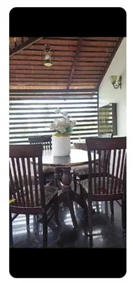 a table with chairs and a vase of flowers on it at Friendly homestay in Mysore