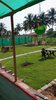a park with picnic tables and a green field at Friendly homestay in Mysore