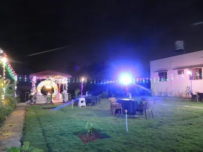 a garden with a table and lights at night at Friendly homestay in Mysore