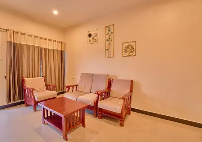 a waiting room with chairs and a table at Pine Forest View Ooty by VOYE HOMES in Ooty
