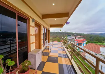 a balcony of a house with a checkerboard floor at Pine Forest View Ooty by VOYE HOMES in Ooty