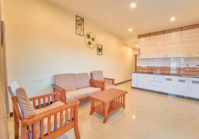 a living room with a couch and a table at Pine Forest View Ooty by VOYE HOMES in Ooty