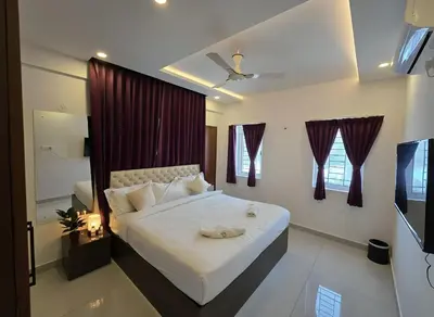 a bedroom with a bed and a television in it at Broadway Inn in Mysore