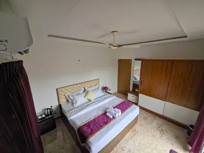 a bedroom with a bed with a stuffed animal on it at Broadway Inn in Mysore