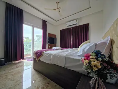 a bedroom with a large bed with flowers on it at Broadway Inn in Mysore