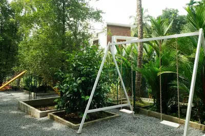 a garden with a swing in front of some plants at Villa La Vista Homestay in Calicut