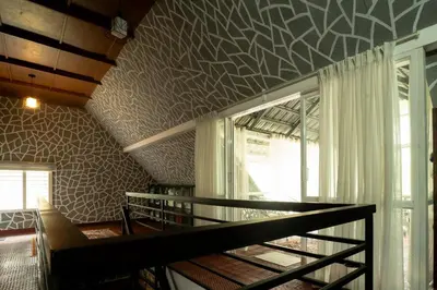 a room with a ceiling with a patterned wall at Villa La Vista Homestay in Calicut