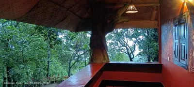 a view of a tree from a room with a window at Naturia in Ambalavayal