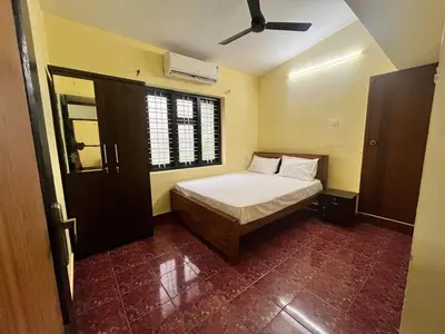 a small bedroom with a bed and a window at Bluebell Homes B- 2bhk Upstairs in Kozhikode