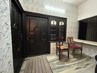a room with a black door and two chairs and a table at Bluebell Homes B- 2bhk Upstairs in Kozhikode