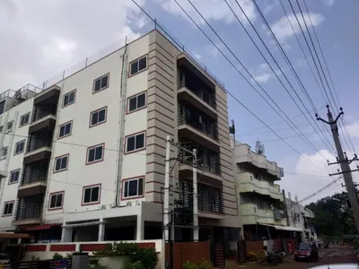 a white building with many windows on a street at SPICE HOMESTAY Apartment in Singānallūr