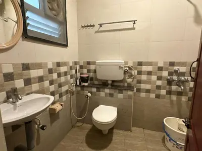 a bathroom with a toilet and a sink at SPICE HOMESTAY Apartment in Singānallūr
