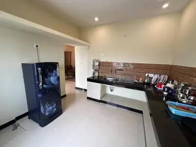 a kitchen with a black refrigerator in a room at SPICE HOMESTAY Apartment in Singānallūr