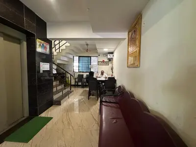 a hallway with people sitting at a table in a restaurant at SPICE HOMESTAY Apartment in Singānallūr