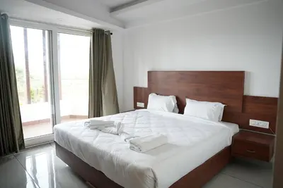 a bedroom with a large bed with two towels on it at Pearl Residency Kalady in Kāladi