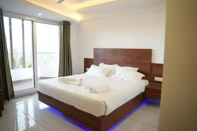 a bedroom with a large bed with a large window at Pearl Residency Kalady in Kāladi