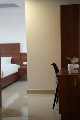 a bedroom with a bed and a desk with a potted plant at Pearl Residency Kalady in Kāladi