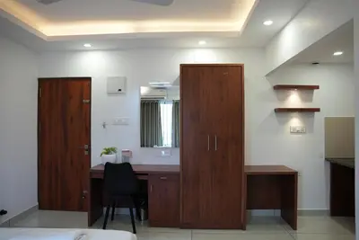 a bedroom with a desk and a mirror and a chair at Pearl Residency Kalady in Kāladi